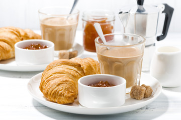 coffee with milk and croissants with jam for breakfast, closeup