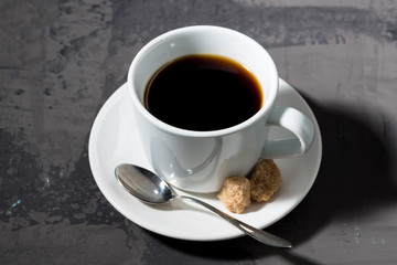 cup of black coffee on a dark background, top view