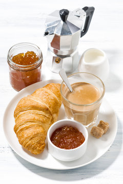 coffee with milk and croissants with jam for breakfast, vertical top view