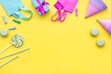 Gift box and colorful paper bag on yellow background top view space for text