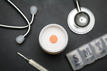 Antibiotic on bottle of medicine. Medicine and medical equipment on black desk. Health care checkup. Aspirin.