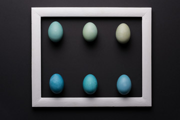 Happy Easter black and white background. DIY dyed shades of blue Easter eggs abstract minimal concept.