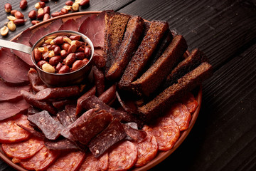 Big set of snacks for beer or alcohol and it includes nuts, saucage, salami and rye bread