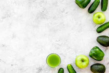 Greeny vegetable smoothie in glass with cucumber, pepper, apple on stone background top view mock up