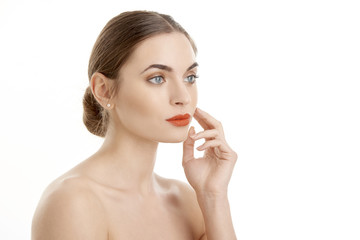 Naklejka premium Close-up of beautiful young woman with red lips looking at camera while posing at isolated white background. Beauty shot in studio.