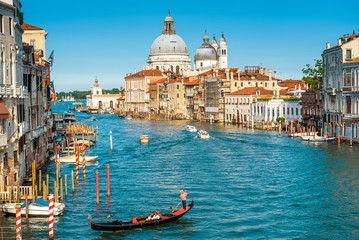 Fototapeta na wymiar Gondola with tourists sails along the Grand Canal in Venice, Italy