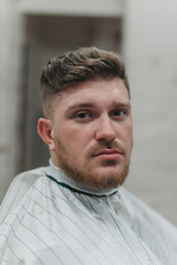 Obraz premium A man in a barber shop for haircuts and shaving