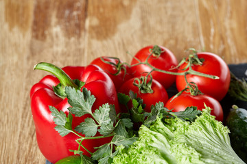 Close-up still life of assorted fresh vegetables and herbs on wooden rustic background, top view, selective focus.