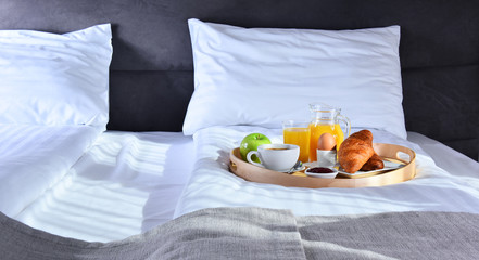 Breakfast on tray in bed in hotel room