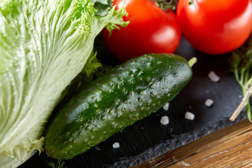 Close-up still life of assorted fresh vegetables and herbs on wooden rustic background, top view, selective focus.