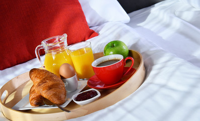 Breakfast on tray in bed in hotel room