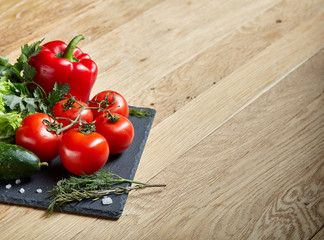 Close-up still life of assorted fresh vegetables and herbs on wooden rustic background, top view, selective focus.