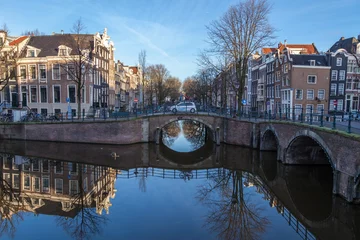 Papier Peint photo autocollant Canal water canals in Amsterdam with a bridge in the middle and traditional architecture