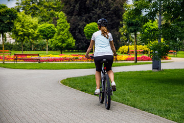 Naklejka premium Healthy lifestyle - woman riding bicycle in city park