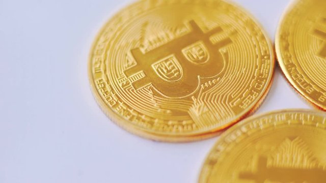 Macro shot of golden bitcoins rotating on background
