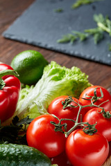 Close-up still life of assorted fresh vegetables and herbs on wooden rustic background, top view, selective focus.