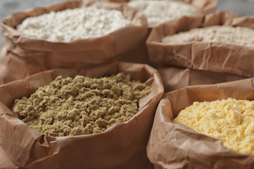 Paper bags with different types of flour, closeup