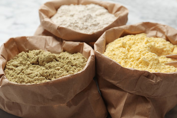 Paper bags with different types of flour, closeup
