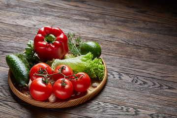 Close-up still life of assorted fresh vegetables and herbs on vintage wooden background, top view, selective focus.