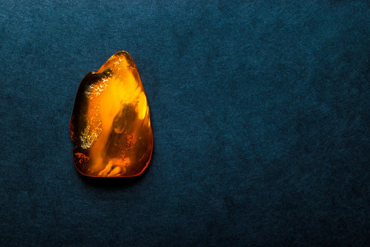 Amber Stone on Dark Blue Background Surface With Free Space