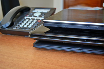 three close black notebook stack of and stationary phone on work office wooden table in cabinet