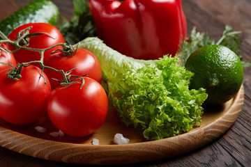 Close-up still life of assorted fresh vegetables and herbs on vintage wooden background, top view, selective focus.