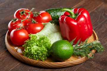 Close-up still life of assorted fresh vegetables and herbs on vintage wooden background, top view, selective focus.