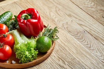 Close-up still life of assorted fresh vegetables and herbs on vintage wooden background, top view, selective focus.