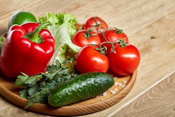 Close-up still life of assorted fresh vegetables and herbs on vintage wooden background, top view, selective focus.