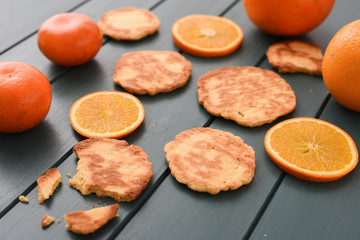 Healthy vegetarian snack. Homemade cookies, clementines and oranges on dark blue background
