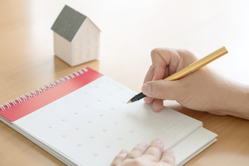 Fototapeta premium hand holding pen and marking on calendar