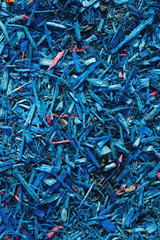 Textured background decorative colored sawdust for finishing flowerbeds in the winter season. Blue sawdust