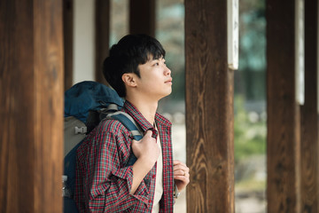 A young man doing a backpacking trip in a Korean traditional house.