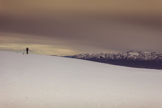Man who takes photographs of the snow, with the Dolomite peaks in the background, Col Visentin, Belluno, Italy