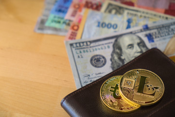 Golden Bitcoin and Litecoin Cryptocurrency digital payment system with  wallet and dollar banknotes on wooden table background. Cryptocurrency Trading concept