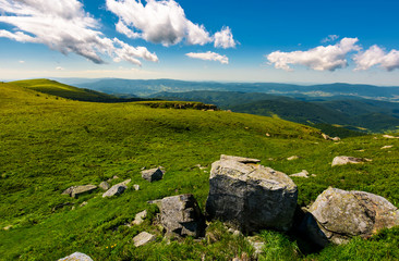 Fototapeta na wymiar gorgeous mountain landscape on a summer day. giant boulders on a grassy hillside under the beautiful sky with clouds. 