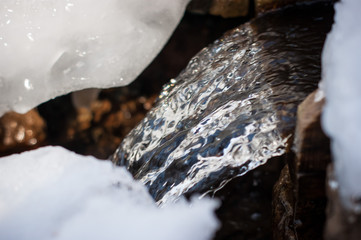 Spring water. A small eco-friendly natural source of clean drinking water. Ice water flows down a small waterfall.