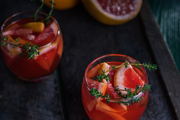 Grapefruit and thyme cocktail. Refreshing drink on rustic background.