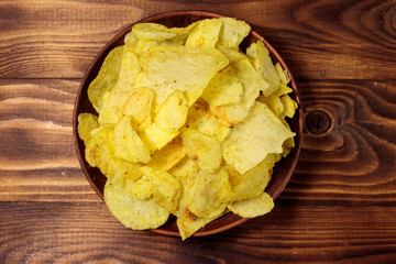 Plate of potato chips on wooden table