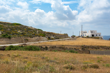 Typical Greek landscape with white houses and flelds. Milos island. Cyclades, Greece.