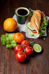 Lunch sandwich with cheese and vegetables served with citrus and coffee, selective focus, close-up, top view