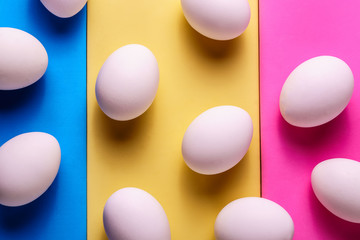 Organic white eggs in a raw on pastel backgound.