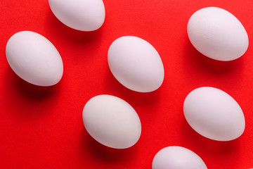 Organic white eggs in a raw on red backgound.