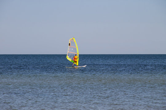 Windsurfing. Surfer exercising in calm sea or ocean.