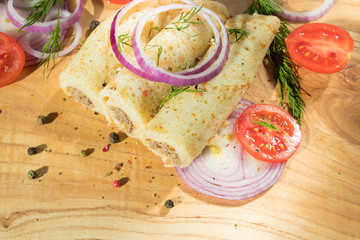 Pancakes with meat are laid out on a wooden board.