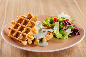 Savory Belgian waffles with cheese sauce and salad