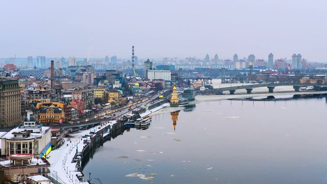 Kyiv, Ukraine. Aerial view of Podol and Dnipro river in the evening in Kyiv, Ukraine. Modern buildings and car traffic. Time-lapse at sunset, getting dark