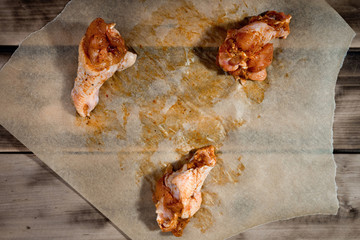 Raw marinated chicken wings on parchment -  ready for cooking.