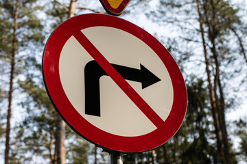 No turn road sign Road markings standing by a forest road.