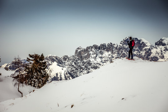 Man on snowy meadows that admires the Dolomite peaks, Col Visentin, Belluno, Italy